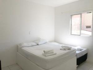 a white room with a bed with towels on it at Casa Brisa in Fortaleza