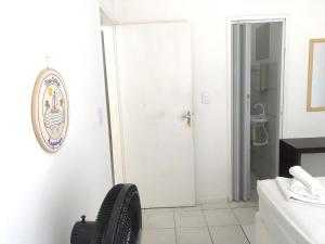 uma casa de banho branca com uma cadeira preta num quarto em Casa Brisa em Fortaleza