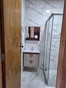 een badkamer met een wastafel en een glazen douche bij Pousada Saint James in Águas de Lindóia