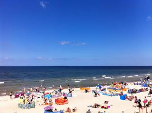 a group of people on a beach with the ocean at Apartament Ella in Międzywodzie