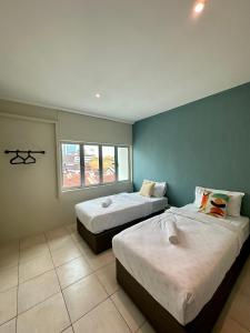 um quarto com duas camas e uma janela em Swing & Pillows @ Malabar em George Town