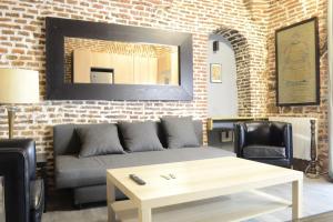 a living room with a couch and a brick wall at Cozy Loft - Royal Palace in Madrid