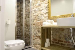 W łazience znajduje się toaleta, umywalka i lustro. w obiekcie Cozy Loft - Royal Palace w Madrycie