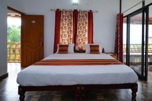 AnachalにあるOYO M S Holiday Resortのベッドルーム1室(大きなベッド1台、大きな窓付)