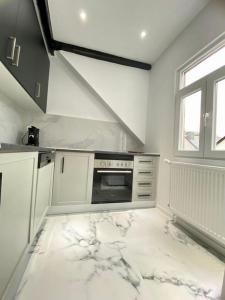 cocina blanca con fogones y ventana en -2-zentral-TraumWohnung-Rhein, en Oberwesel