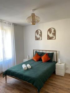 - une chambre dotée d'un lit vert avec deux chaussures dans l'établissement Maison Amarelle : Cocon Kelleris, à Migennes