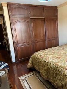 um quarto com uma grande parede de madeira ao lado de uma cama em HABITACIONES PRIVADAS NOVILLO em Cochabamba