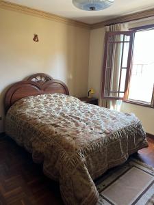 um quarto com uma cama grande num quarto com uma janela em HABITACIONES PRIVADAS NOVILLO em Cochabamba