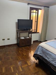 - une chambre avec un lit et une télévision sur une table dans l'établissement HABITACIONES PRIVADAS NOVILLO, à Cochabamba
