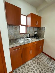 a kitchen with wooden cabinets and a sink at Casa Sol in Oaxaca City