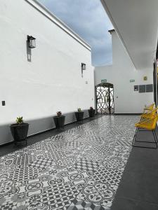 Habitación con pared blanca y suelo de baldosa. en Casa Sol en Oaxaca de Juárez
