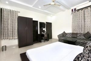 a bedroom with a bed and a living room at Capital O Hotel Nayyar in Amritsar