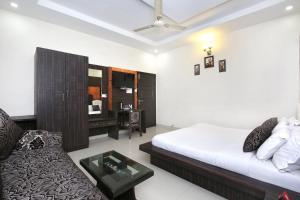 ein Schlafzimmer mit einem Bett, einem Sofa und einem Tisch in der Unterkunft Collection O Hotel Nayyar in Amritsar