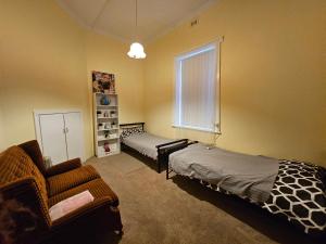 - une chambre avec un lit, un canapé et une fenêtre dans l'établissement Spacious Holiday Home-Ramco, à Waikerie