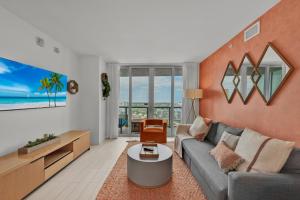 a living room with a couch and a table at Water View Building With Pool - 5-Min Walk To The Beach in Hallandale Beach
