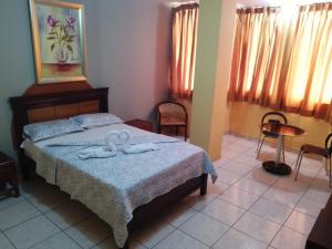1 dormitorio con 1 cama con 2 toallas en Olmedo Plaza Hotel en Guayaquil