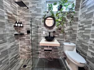 a bathroom with a toilet and a sink and a mirror at Casa Tsunuum in Holbox Island