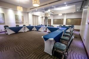 une salle de conférence avec des tables et des chaises bleues dans l'établissement Parque del Lago Boutique Hotel, à San José