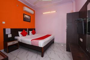 1 dormitorio con 1 cama con pared de color naranja en Super OYO Hotel Haveli Inn1 en Varanasi