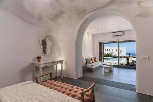 1 dormitorio con cama, chimenea y sala de estar. en Numa Santorini en Fira