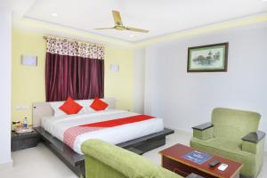 a hotel room with a bed and a chair at Hotel Sai Golden Rooms in Tirupati