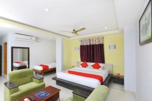 a bedroom with a bed and a couch and a chair at Hotel Sai Golden Rooms in Tirupati