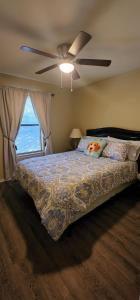 une chambre avec un lit avec un ventilateur de plafond dans l'établissement The Cozy Corner House at Haltom City Texas, à Haltom City