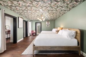 a bedroom with two beds and a ceiling covered in leaves at Victoria 1883 in New Smyrna Beach