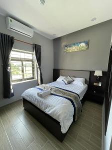 a bedroom with a bed and a window at Anna Hotel Binh Duong in Bến Cát