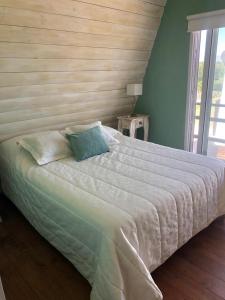 a bedroom with a large bed with a wooden wall at Brisas del Ceferino in Sierra de la Ventana