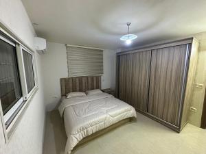 um quarto com uma cama e uma grande janela em شقه مفروشه بمدخل مستقل و موقف لثلاث سيارات مع ساحات خارجيه em Irbid