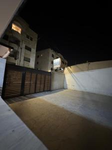 um parque de estacionamento vazio com um portão à noite em شقه مفروشه بمدخل مستقل و موقف لثلاث سيارات مع ساحات خارجيه em Irbid