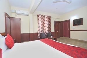 ein Hotelzimmer mit einem Bett und einem TV in der Unterkunft Coorg Mandarin in Madikeri
