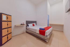 a small bedroom with a bed and a cabinet at Reddoorz near Juwata Airport Tarakan in Tarakan