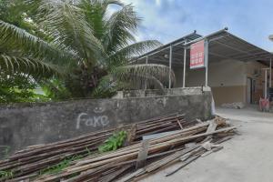 a building with a palm tree in front of it at Reddoorz near Juwata Airport Tarakan in Tarakan