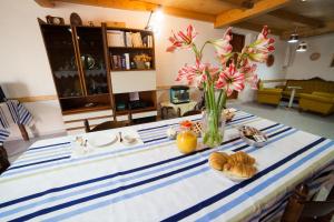 Una mesa azul y blanca con un jarrón de flores. en Acqua di Mare, en Locogrande