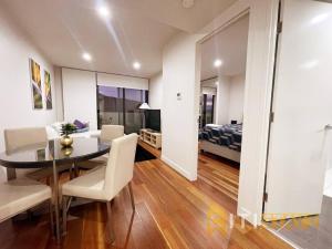 a dining room and living room with a table and chairs at Braddon Bliss - Modern 1Bd 1Bth Haven in Canberra