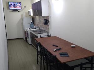 a kitchen with a wooden table with chairs and a refrigerator at Los alamos in Río Gallegos