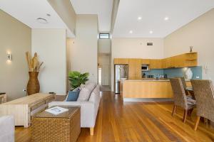 a living room with a couch and a kitchen at Byron Bay Accom Unit 1 2 Fletcher Street Pipis on the Beach 1 in Byron Bay