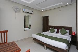 Schlafzimmer mit einem Bett, einem Tisch und einem Spiegel in der Unterkunft Hotel Sea in Patiala