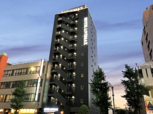 un grand bâtiment noir dans une ville dans l'établissement HOTEL LiVEMAX BUDGET Nagoya Taikodori, à Nagoya