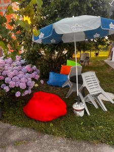 a chair and an umbrella next to some flowers at Yahya Rooms in Ohrid