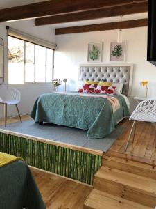 a bedroom with a large bed with a green comforter at Hostal Napoli in Valparaíso