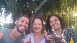 3 persone che posano per una foto con bevande di Pousada OPA - O Paraíso é Aqui Abrolhos a Caravelas