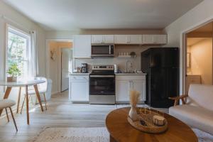 cocina con armarios blancos y mesa en la sala de estar en Sage Haven #3, en Johnson City