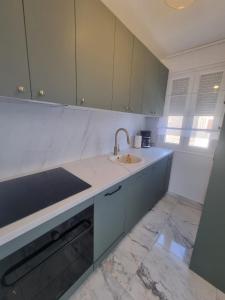 a white kitchen with a sink and a dishwasher at Apartment with view on city marine in Zadar