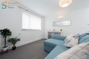 a living room with a blue couch and a window at Stylish ground floor apartment in Margate