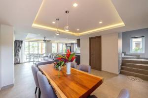 - une salle à manger avec une table et des chaises en bois dans l'établissement Sevens Paradise Pool Villa - Koh Chang, à Ko Chang