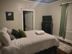 a bedroom with a bed with towels on it at 2br Hideaway just 2 miles from Beale St and Overton Square! in Memphis