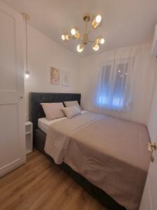 Schlafzimmer mit einem Bett und einem Kronleuchter in der Unterkunft Apartment with view on city marine in Zadar